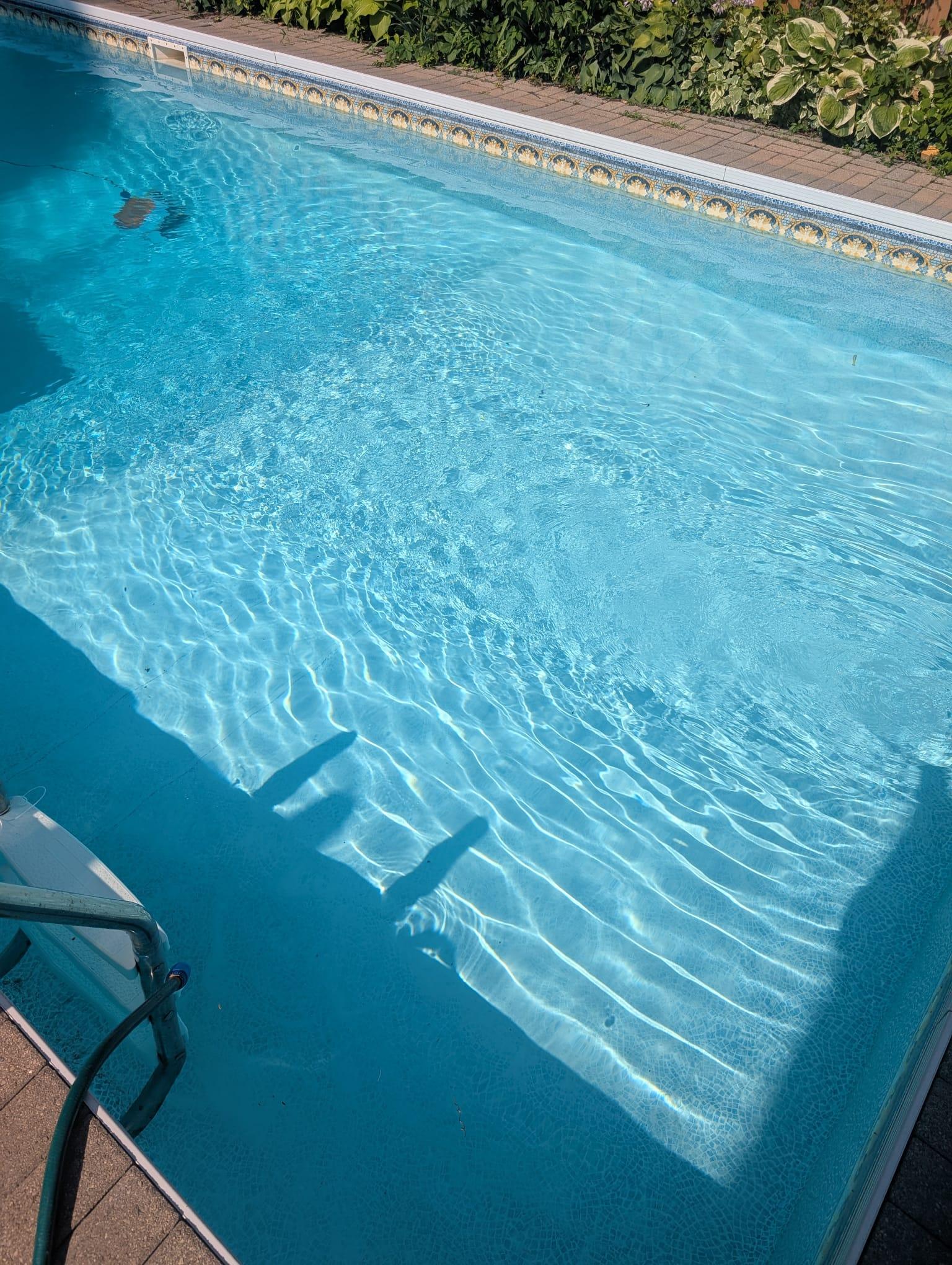Child practicing swimming with instructor support